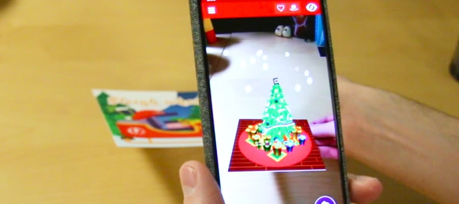 Alex using his phone to experience the augmented reality Christmas card
